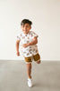 Boy jumping in the white and black leather little love bug sneakers