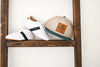 White and black little love bug sneakers next to a hat