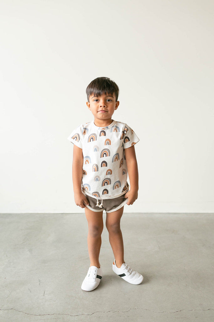 Boy standing in the white and black little love bug sneakers.