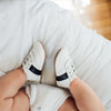 baby wearing the white and black little love bug sneakers