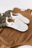 A pair of Little Love Bug co white leather quinn shoes.