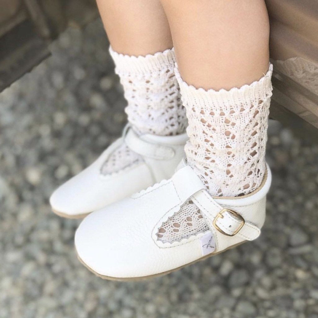 Child wearing the white leather anti-slip shoes, made by  Little Love Bug Co.