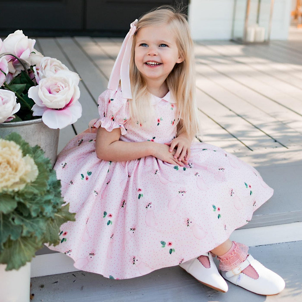 Girl in dress wearing  Little Love Bug Co. white t bar leather shoes.