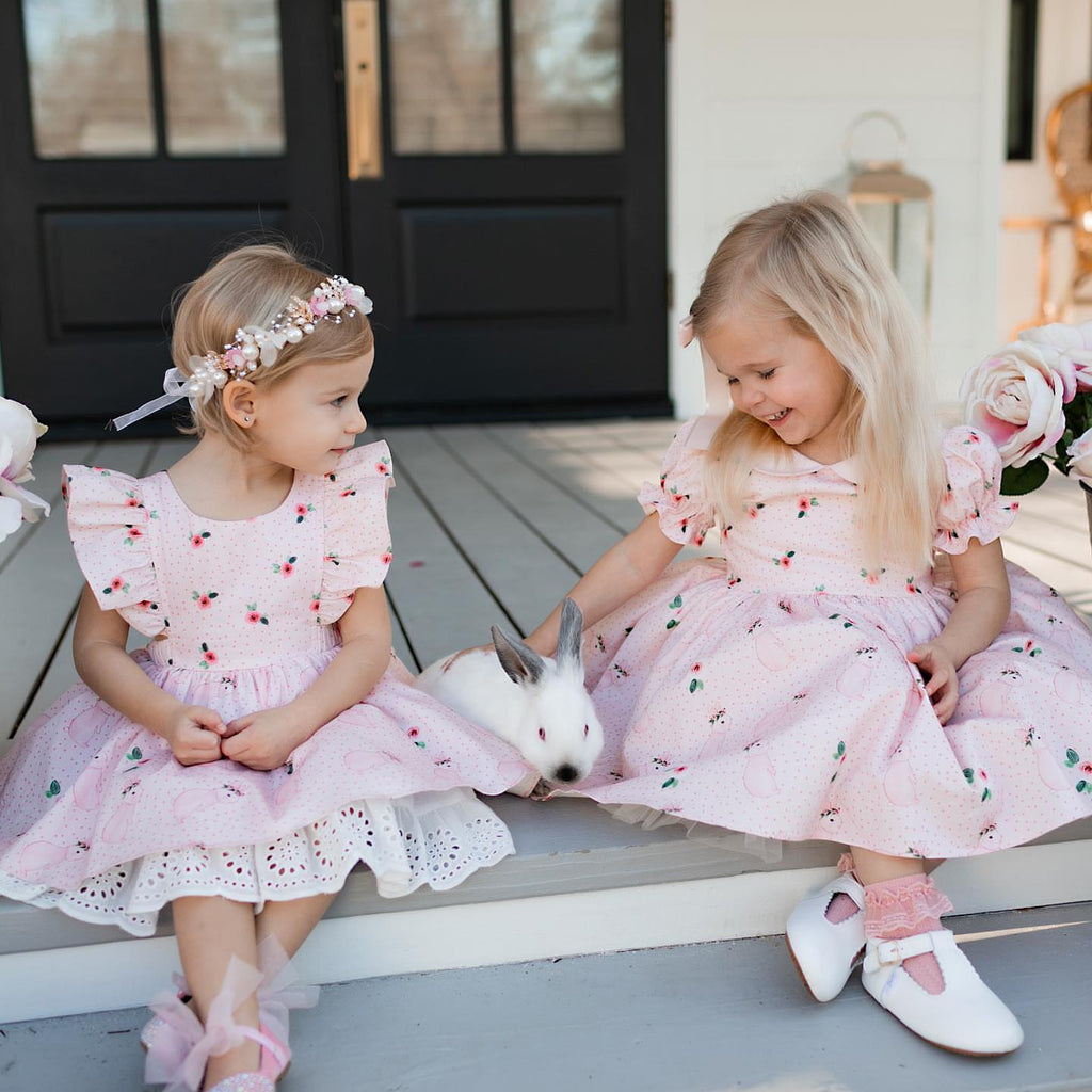 Two girls wearing the  Little Love Bug Co. white t-bar shoes