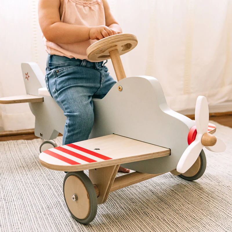 Side view of Wonder & Wise Airplane Ride-On Toy with steering wheel and propeller, Montessori-inspired ride-on for toddlers