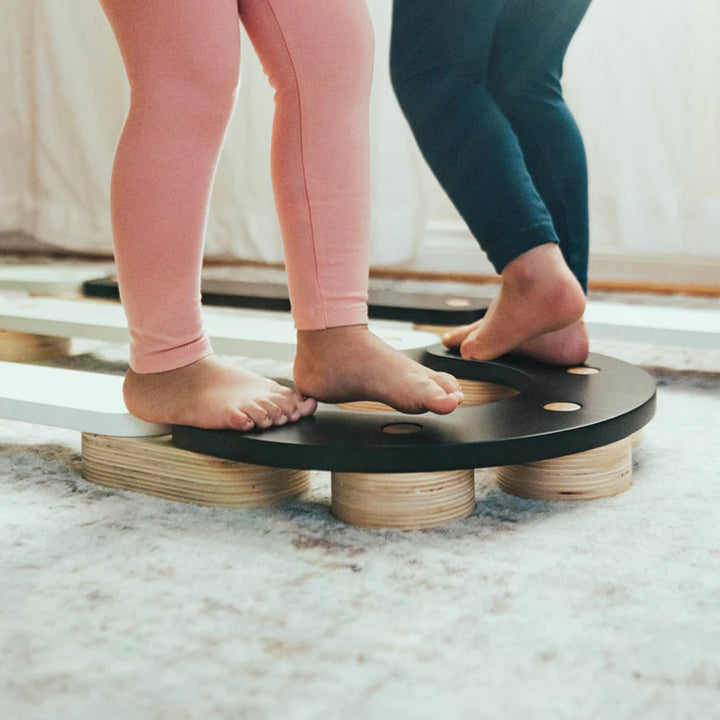 Close-up of feet on Wonder & Wise Balance Beam, Montessori-inspired wooden toy for balance practice