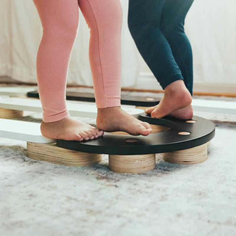 Close-up of feet on Wonder & Wise Balance Beam, Montessori-inspired wooden toy for balance practice
