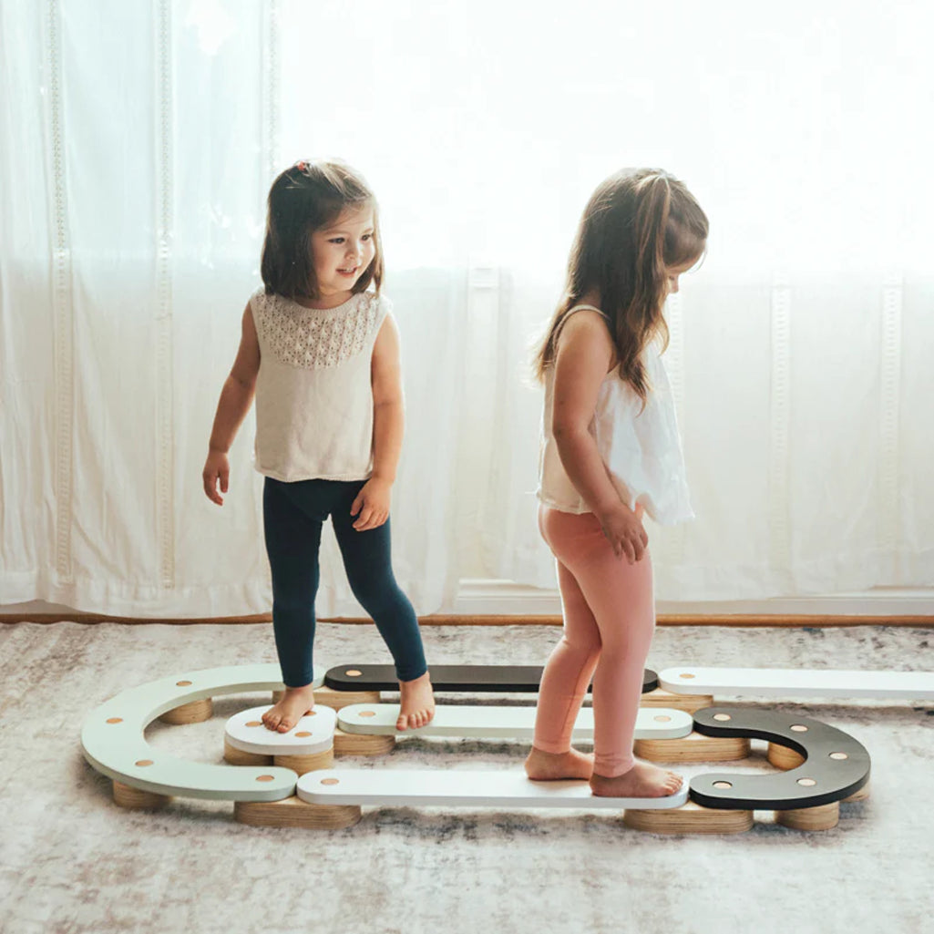 Children playing on Wonder & Wise Balance Beam set indoors, wooden balance toy for gross motor skill development