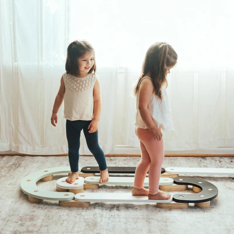 Children playing on Wonder & Wise Balance Beam set indoors, wooden balance toy for gross motor skill development