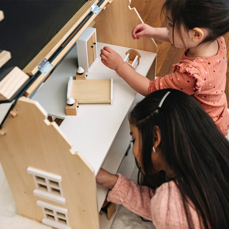 two sisters playing with wonder and wise classic style wooden dollhouse 