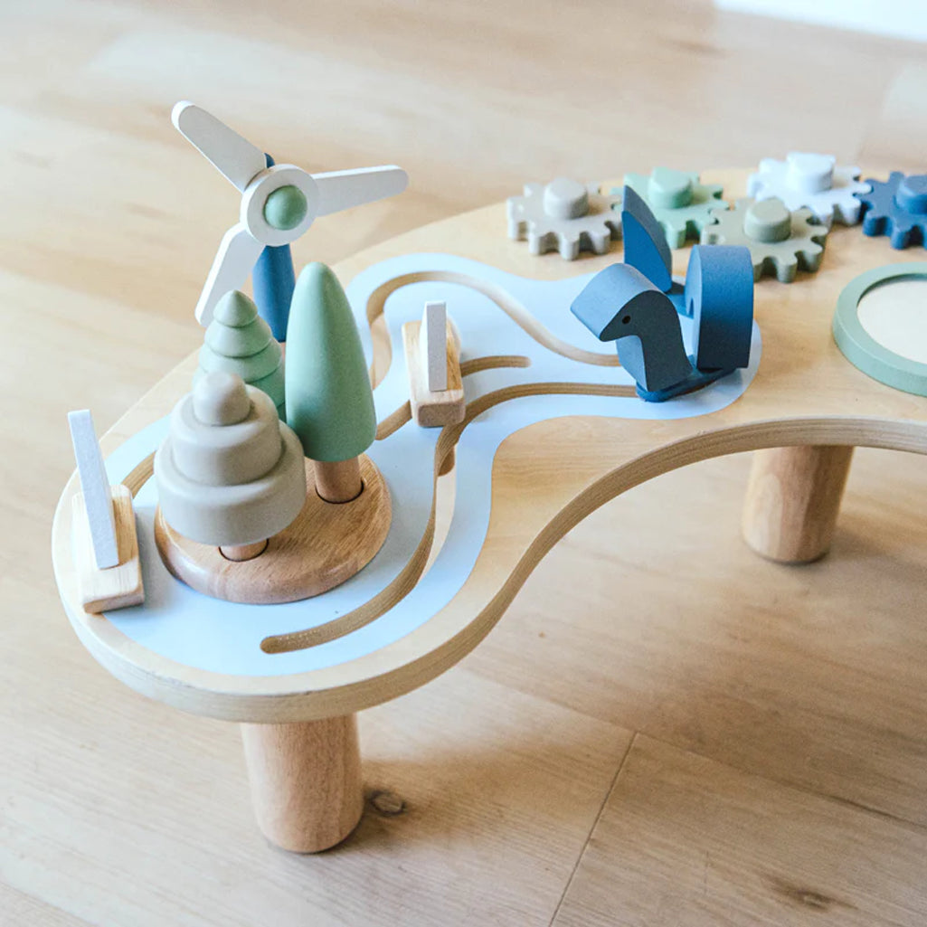 close up of the hi low activity table for baby with wooden trees and windmill 