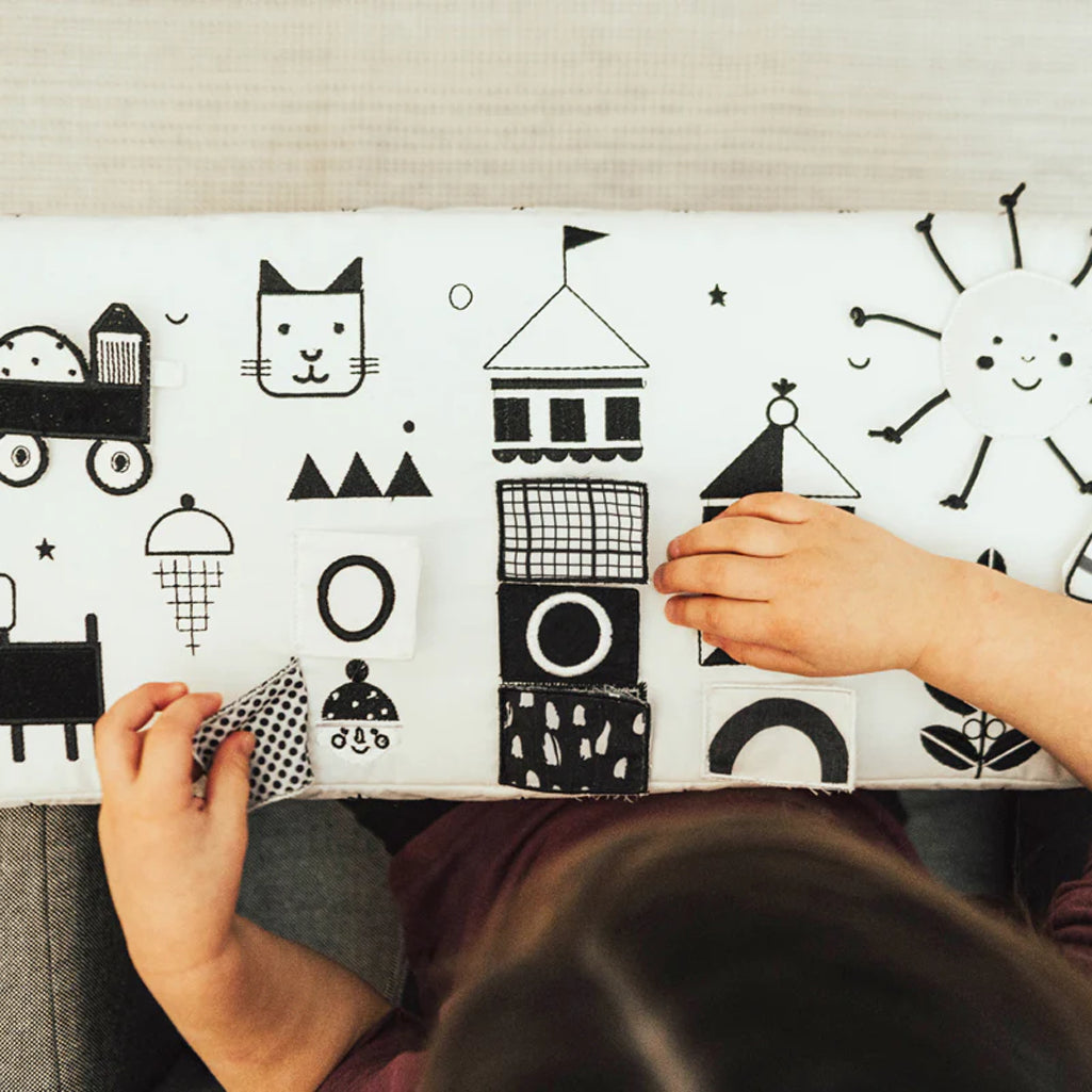 black and white illustrated wonder and wise activity table attached to toddler chair 