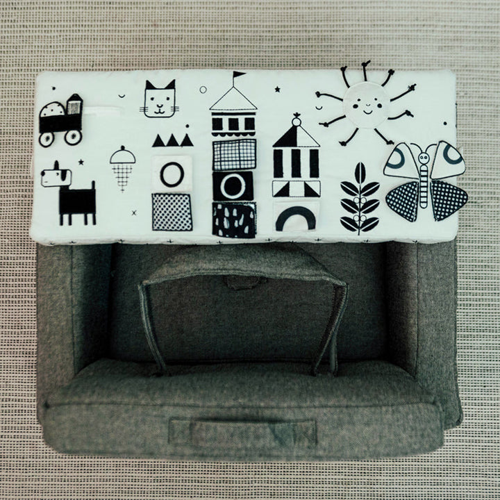 white activity table with hand drawn crinkle toys attached to wonder and wise square chair 