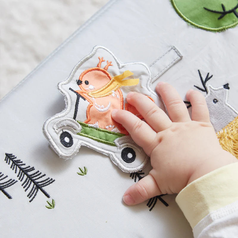 close up of baby touching crinkle toy attached to black and white wonder and wise activity chair for baby 