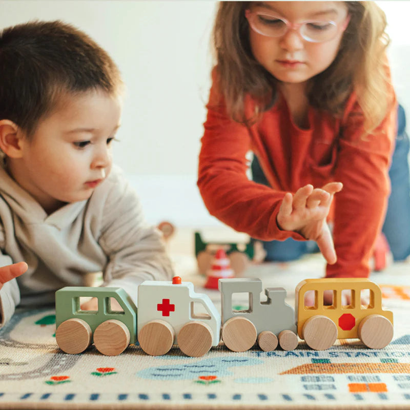 Two children playing together on Wonder & Wise Around Town Play Mat, wooden toy vehicles and buildings for pretend play
