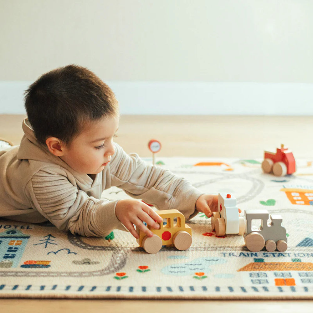 Child playing with Wonder & Wise Around Town Play Mat and wooden vehicles, educational city scene toy for creative learning