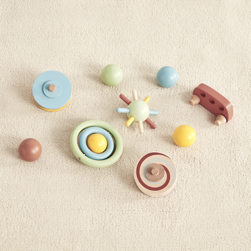group of colorful wooden toys that are included in the wonder and wise tumble track gravitational learning toy 