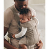 dad holding baby in baby bjorn baby carrier mini in grey beige
