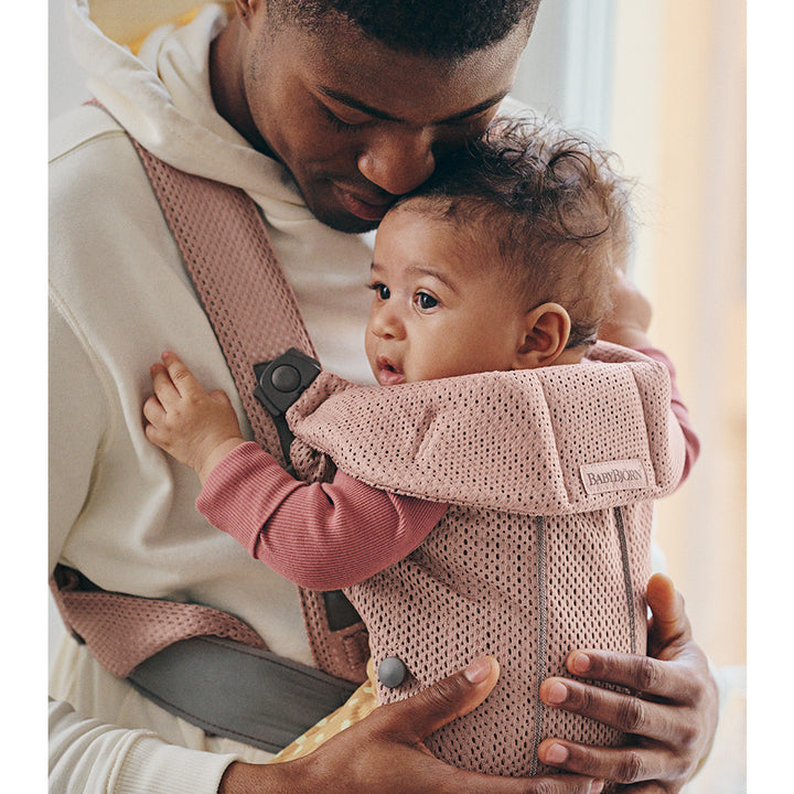 dad caring for baby in babybjorn mini baby carrier dusty pink