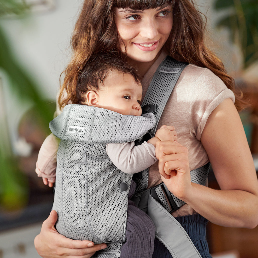 mom and infant facing sideways in babybjorn mini baby carrier grey 3d mesh