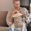 mom holding infant in babybjorn baby carrier mini leopard print