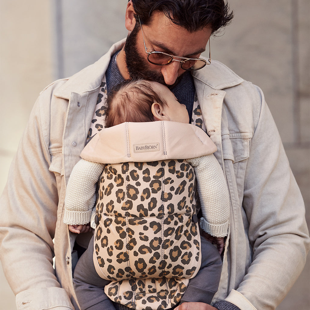 dad ioutdoors with sleeping baby in babybjorn baby carrier mini leopard