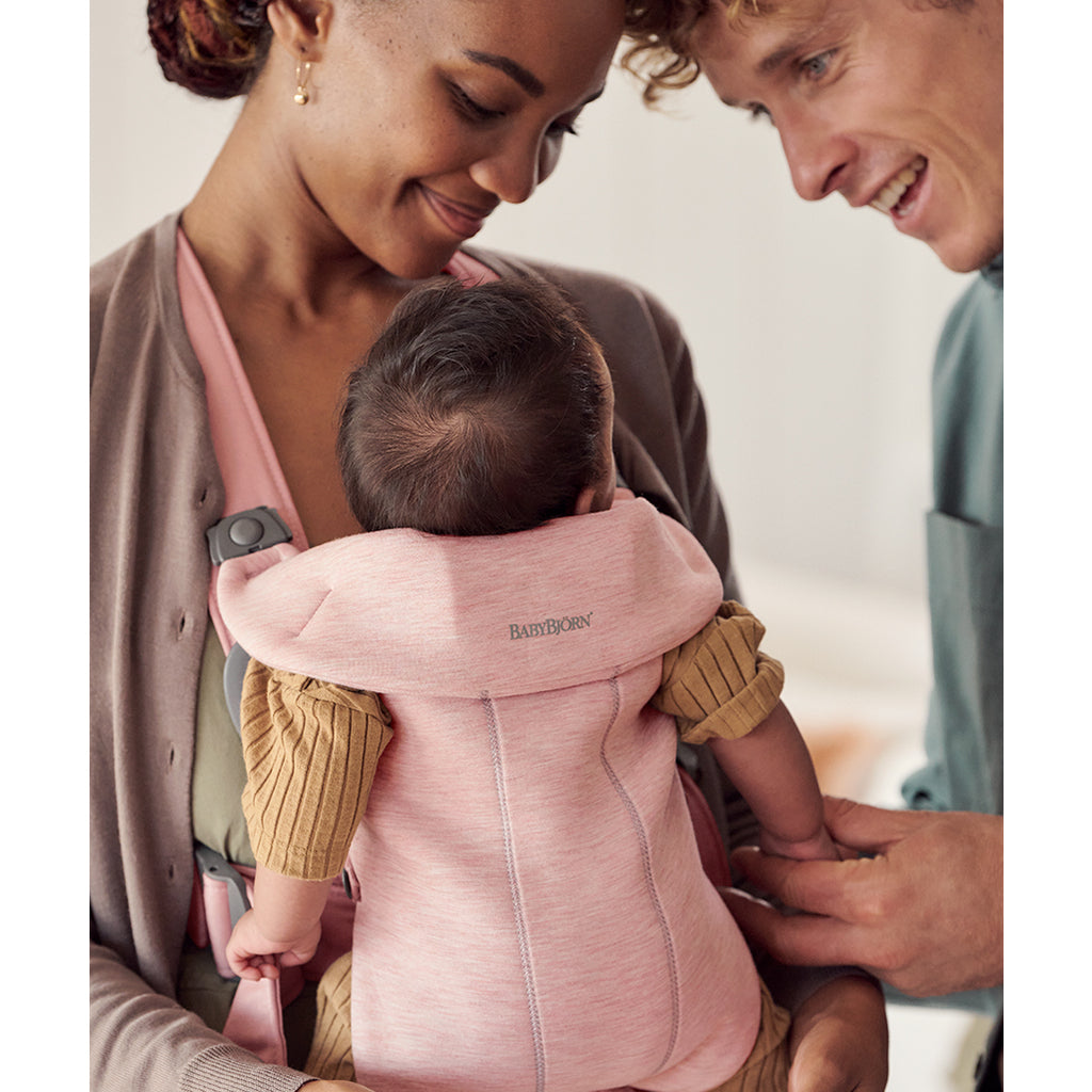 parents smiling at infant in baby bjorn baby carrier mini light pink
