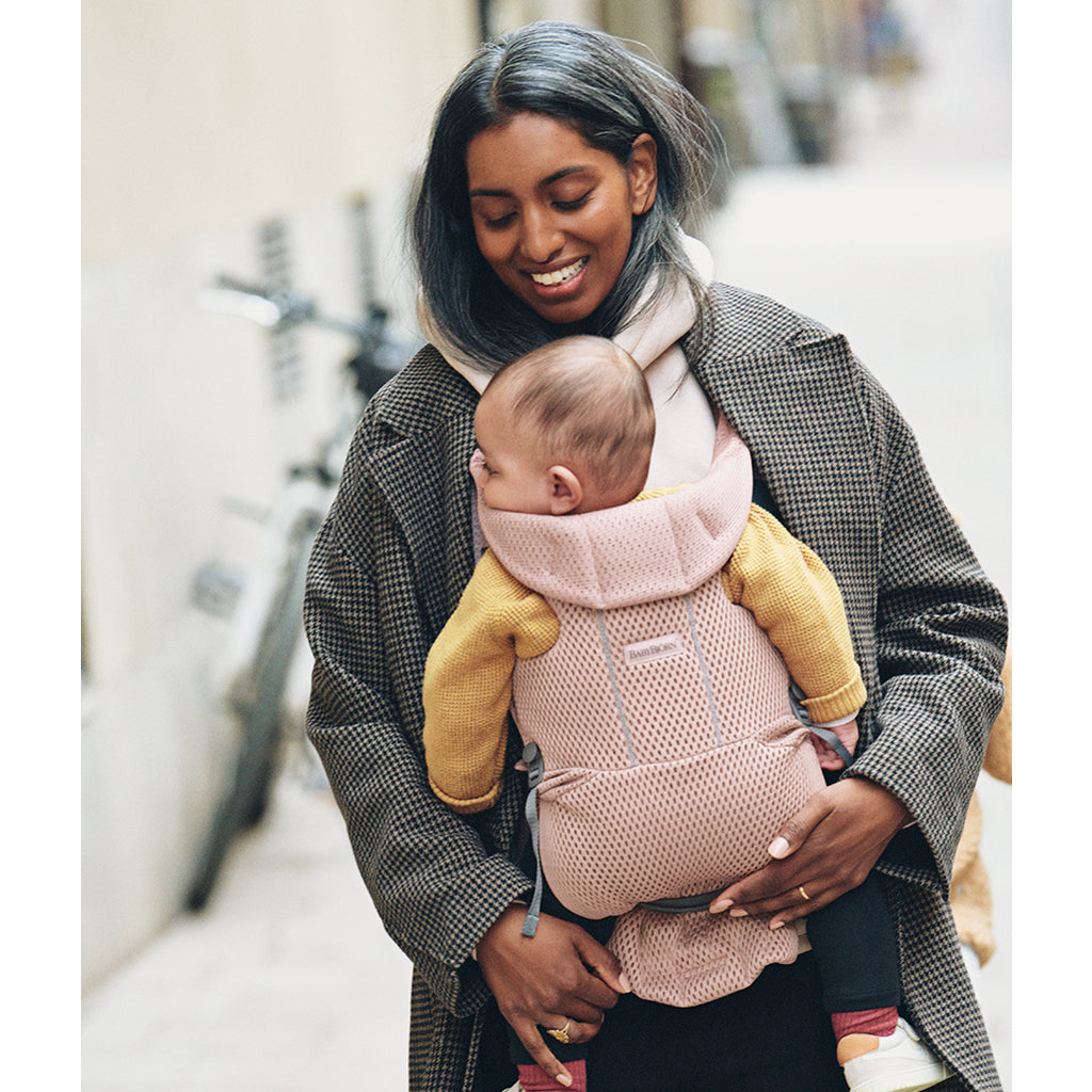 mom smiling at baby in best pink baby bjorn carrier