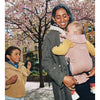 mom attending to two kids with one in pink babybjorn free carrier