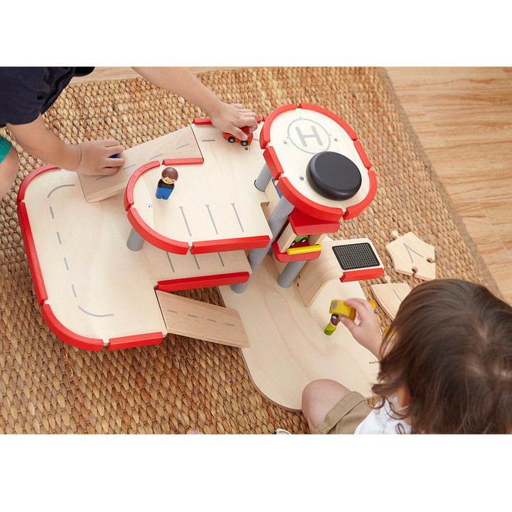 A wooden parking garage playset with vehicles and ramps, perfect for young childrenÕs motor skill development.