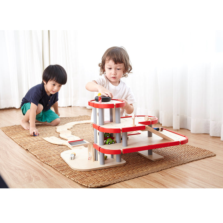 A multi-level wooden parking garage, complete with cars and accessories, ideal for imaginative play.