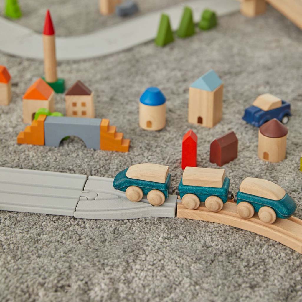 Set of hybrid wooden toy trains by PlanToys, perfect for group play.