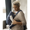 mom holding baby in babybjorn baby carrier mini navy blue