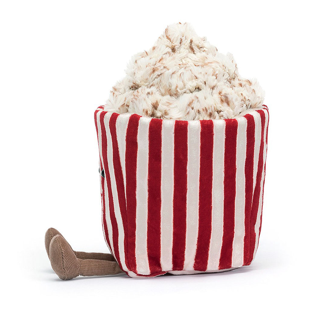 Jellycat Amuseable Popcorn stuffed animal popcorn. Red and white striped container with cream and brown popcorn. Side view.