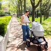 Woman Walking with Uppababy Cruz Stroller with Bassinet Accessory in Anthony