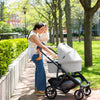 Mom and Toddler Walking with Uppababy Cruz Stroller with Bassinet Accessory in Anthony