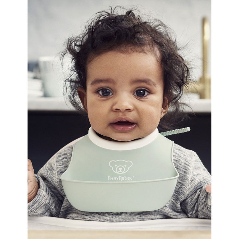 Baby Using Babybjorn Soft Feeding Bib Set in Green, providing reliable protection during meals