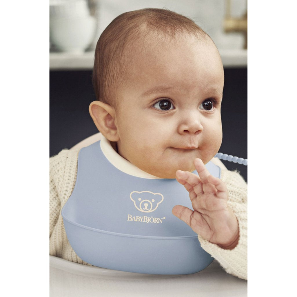 Baby Using Babybjorn Soft Feeding Bib Set in Blue, ideal for first feeding experiences