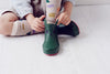 Kid putting on Boxbo Green Kerran Rain Boots for Children