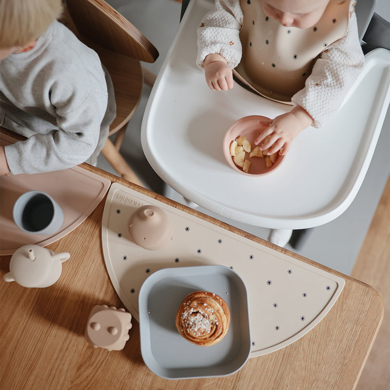 Mushie Placemat in Black Daisy Bold and modern black daisy patterns to create a stylish mealtime experience