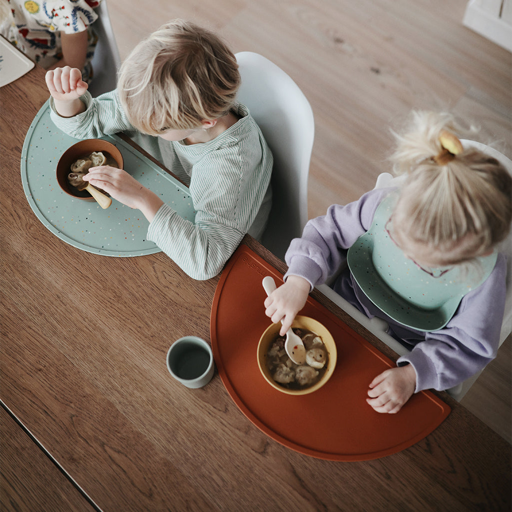 Mushie Silicone Placemats in Clay/Blue Confetti A stylish mix of neutral clay and lively blue confetti for a fun mealtime