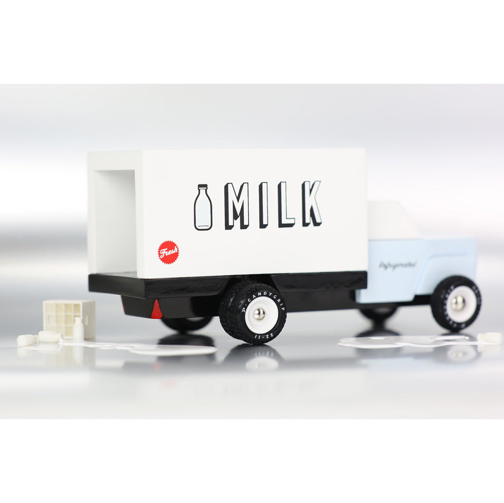 Wooden milk truck by Candylab, shown with toy props for creative storytelling.
