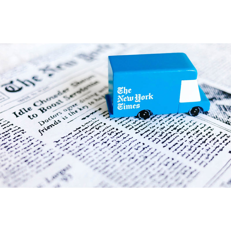 A Candylab Toys New York Times van resting on a newspaper, showing off its design details.