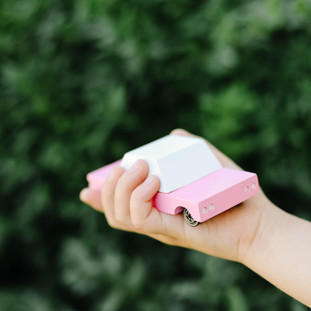 A child holding the Candylab Toys pink sedan, ready for fun playtime in their imaginative world.