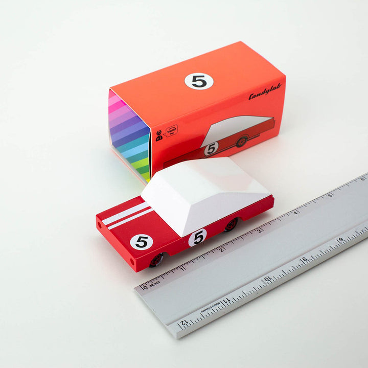A Candylab Toys Red Racer #5 wooden car, perfect for children to use in their pretend racing games.