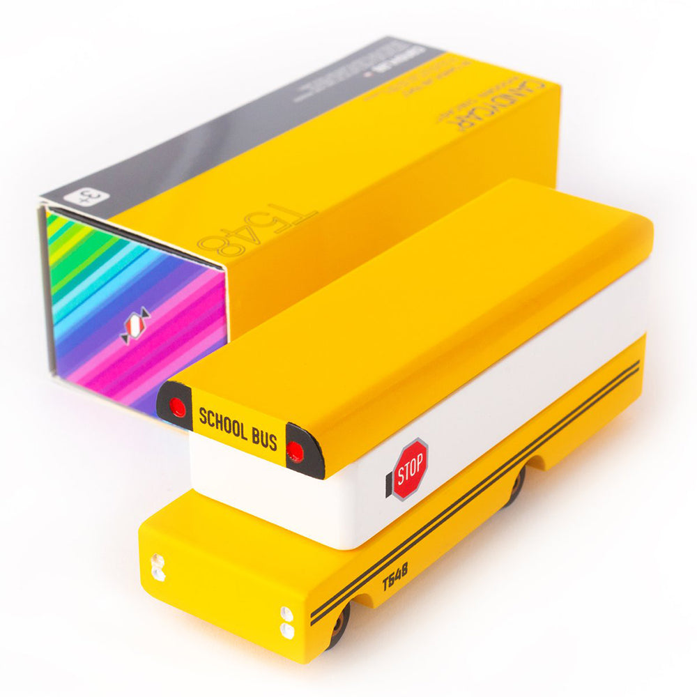 A Candylab Toys yellow wooden school bus toy, packaged and ready for kids to explore.