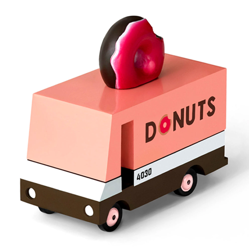 Close-up of the Candylab wooden donut van showcasing pink details and vibrant wheels