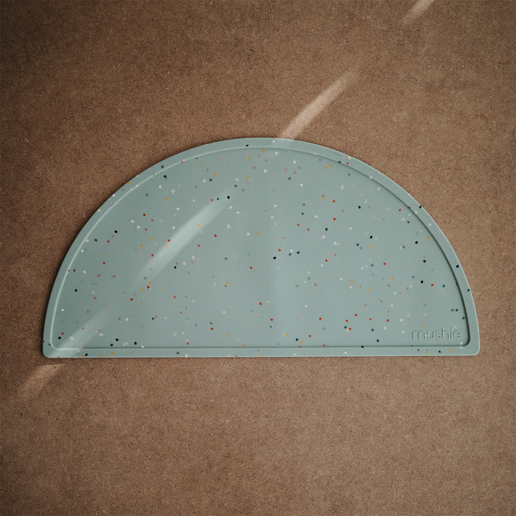 Mushie Silicon Placemat in Blue Confetti Fun and playful blue confetti patterns to create a colorful dining experience