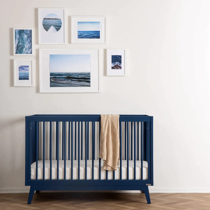 Side angle of the Dadada Soho 3-in-1 Convertible Crib in denim highlighting clean lines and best cribs design.