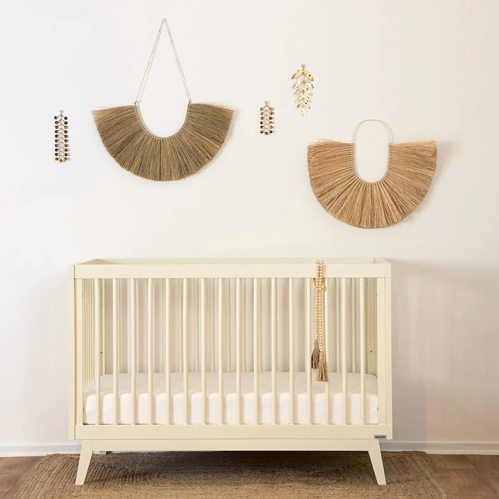 Lifestyle image of the Soho 3-in-1 Crib Meringue in a nursery. Toddle bed rail